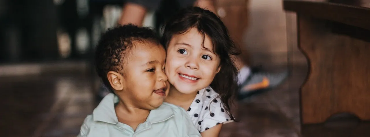 Two young children smiling together