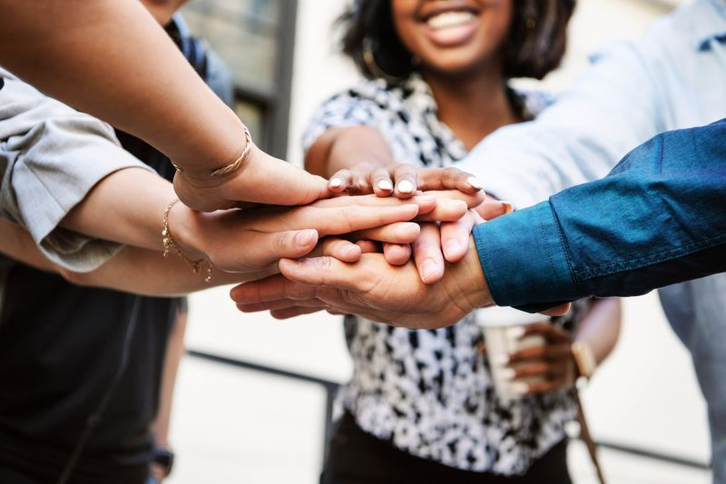 Volunteers placing their hands together